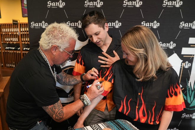 James and Haley Koch get their shirts signed by Guy Fieri at Twins Liquor at the Hancock Center on Thursday, March 28, 2024. Fieri came to Texas in support of his and Sammy Hagar’s Santo Spirits brand.